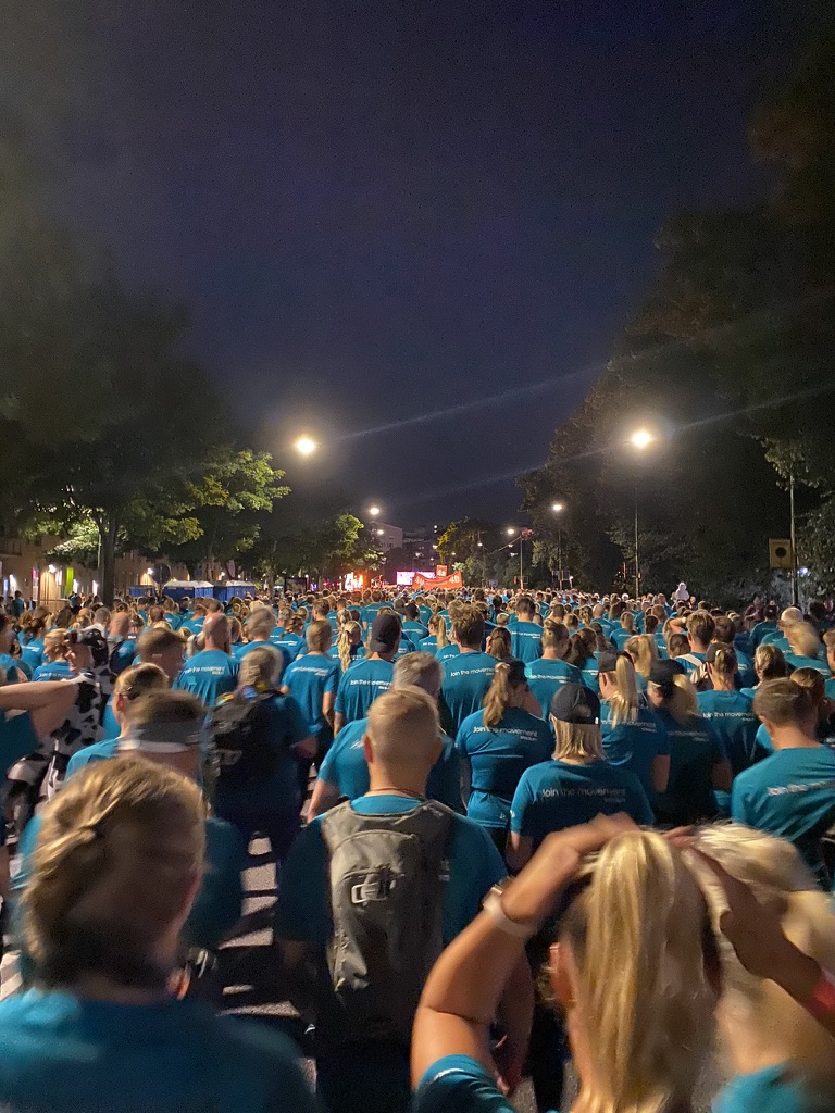 A picture of a sea of people in turquoise t-shirts queuing for the start of midnattsloppet 2024